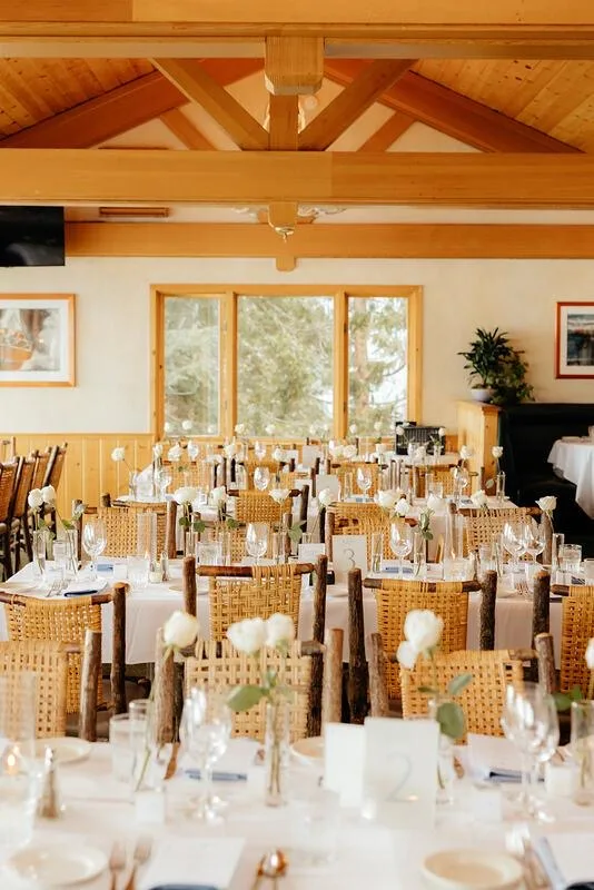 An upstairs private dining room set for an event, with open beam ceilings
